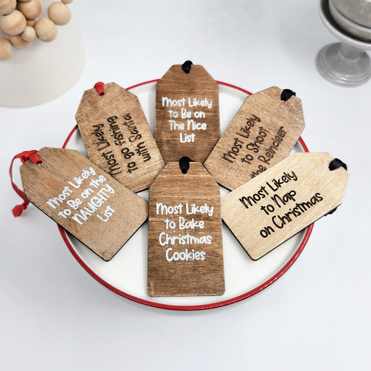 Wooden Christmas tags with humorous sayings on a white surface